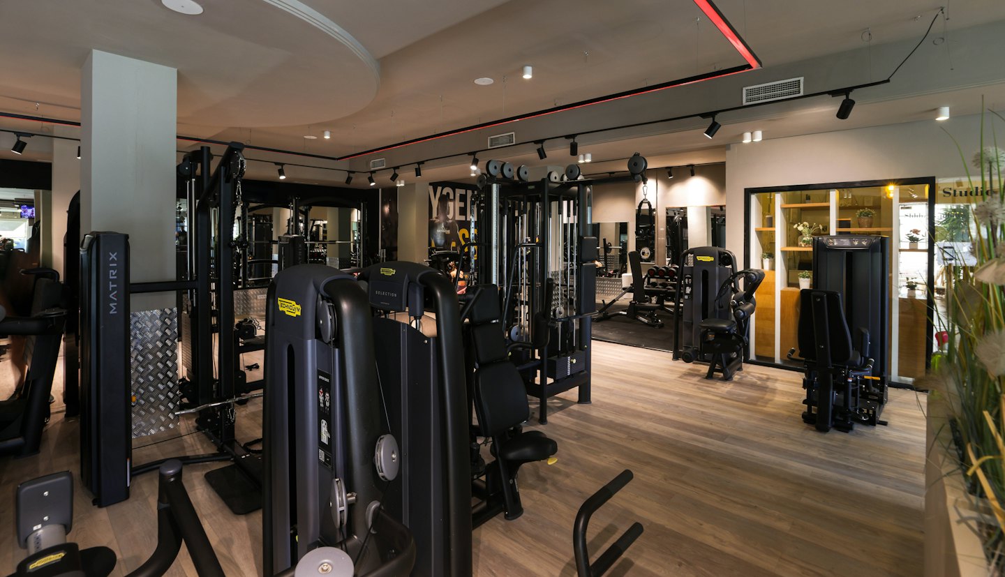 Modernes Fitnessstudio mit professionellen Kraftgeräten und Trainingsausrüstung.
